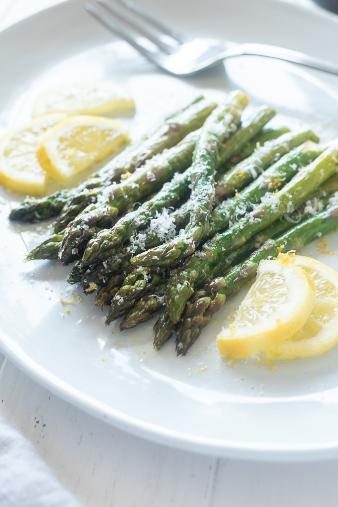 Oven roasted asparagus on a platter with lemon slices