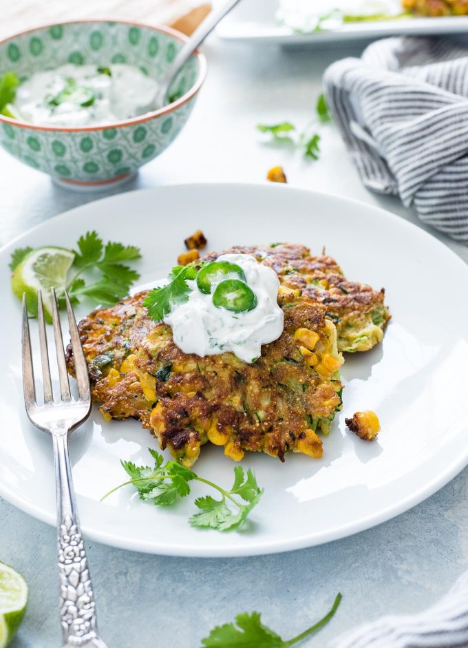 zucchini fritters on a plate topped with yogurt