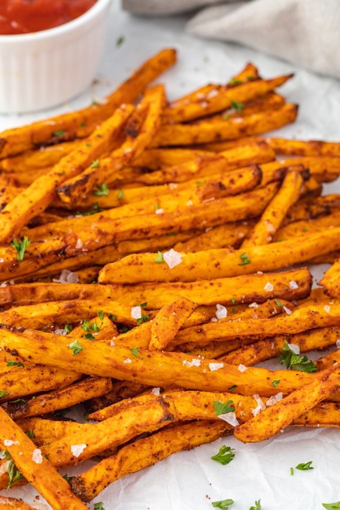 Air fryer sweet potato fries topped with flaky sea salt and parsley