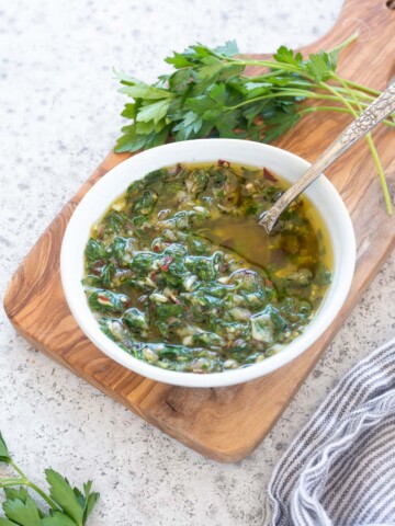 Chimichurri sauce in a bowl with a spoon inside
