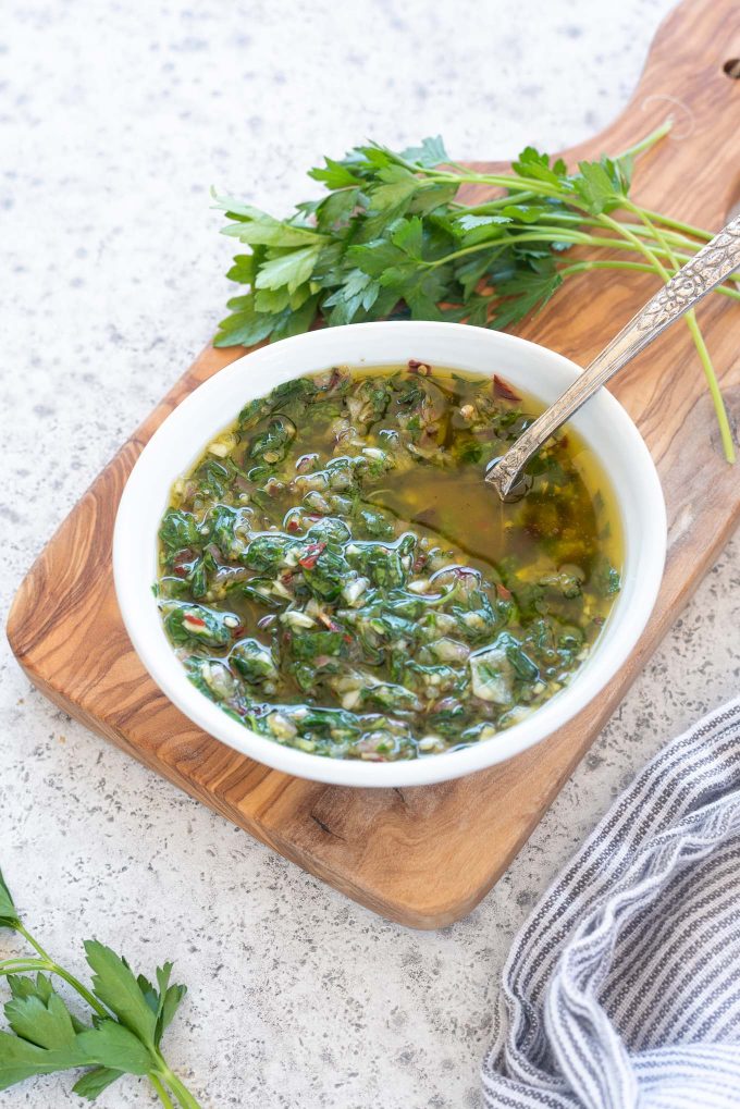 Chimichurri sauce in a bowl with a spoon inside