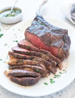 Grilled Tomahawk Steak sliced on a platter