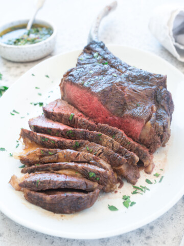 Grilled Tomahawk Steak sliced on a platter