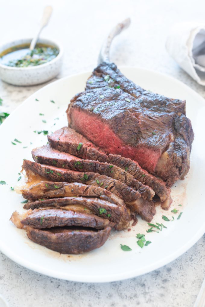 Grilled Tomahawk Steak sliced on a platter
