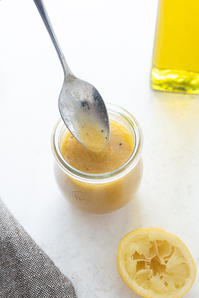 Red wine vinaigrette drizzling off of a spoon into a jar