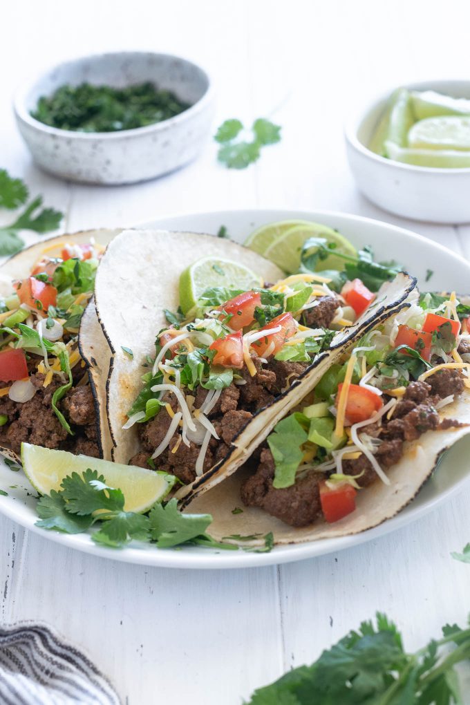 Ground beef tacos on a plate with lime