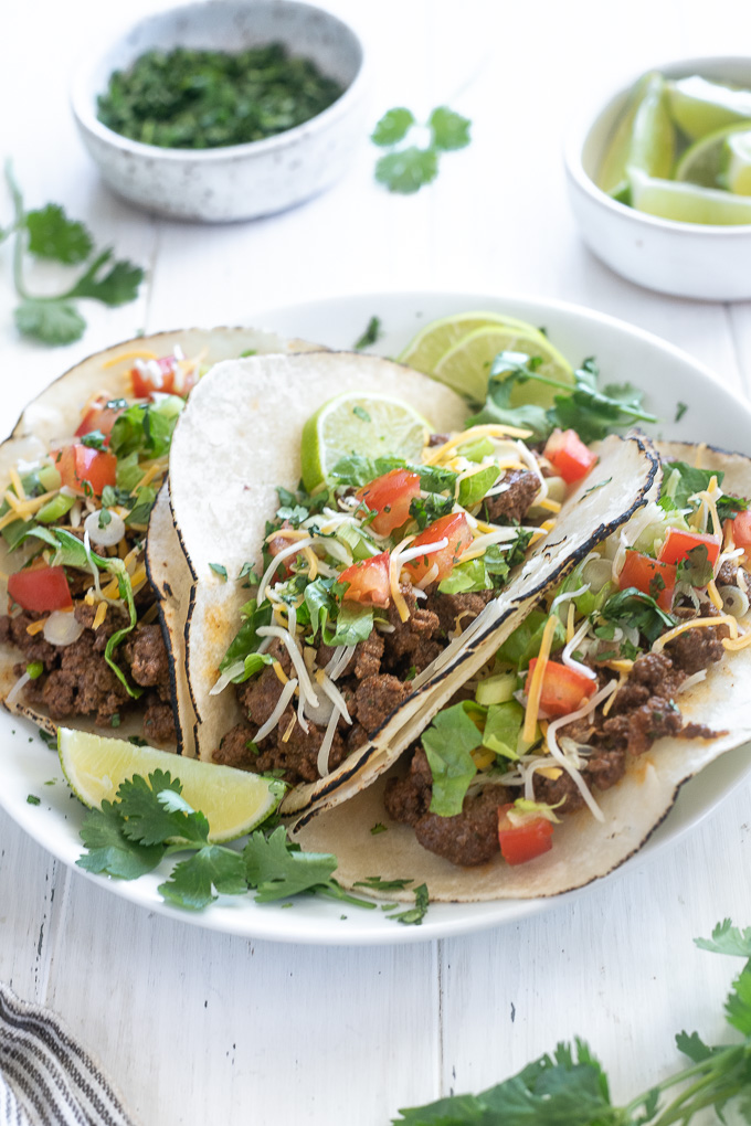 Three ground beef tacos on a white plate