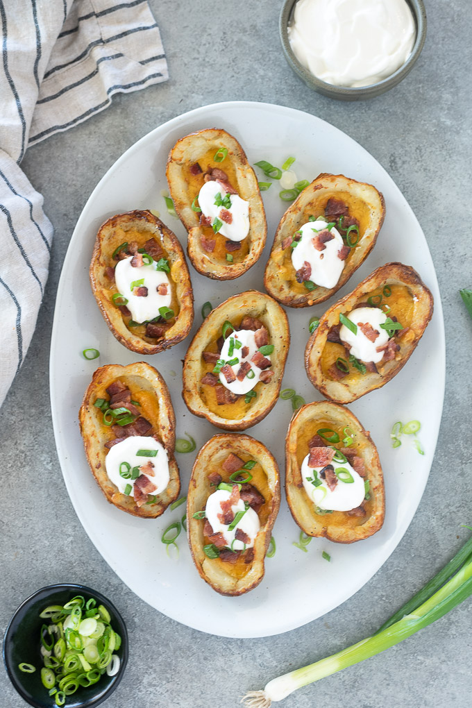 Platter of loaded potato skins garnished with scallions