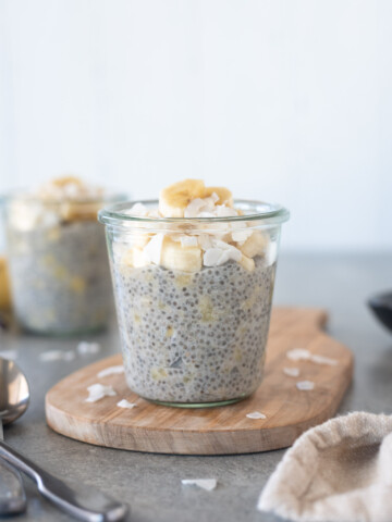 Jar of banana chia pudding on a cutting board