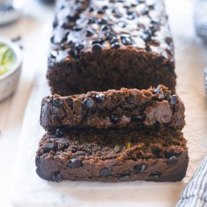 Double chocolate zucchini loaf sliced on a board