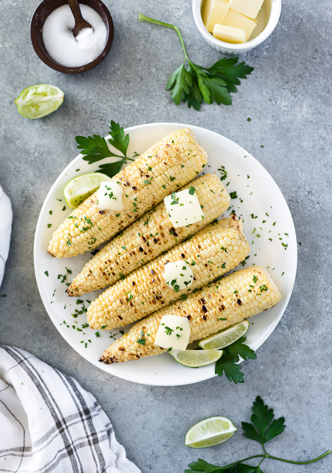 Grilled corn on the cob with melted butter and parsley