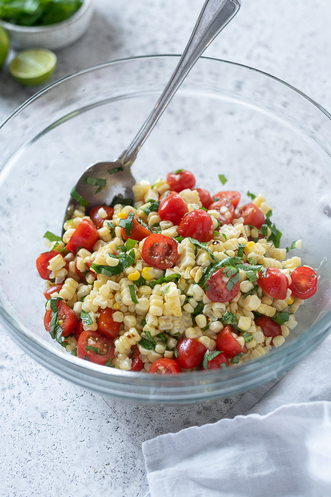 Tomato corn salad tossed in mixing bowl