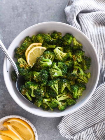 Serving spoon buried in a bowl of air fryer broccoli