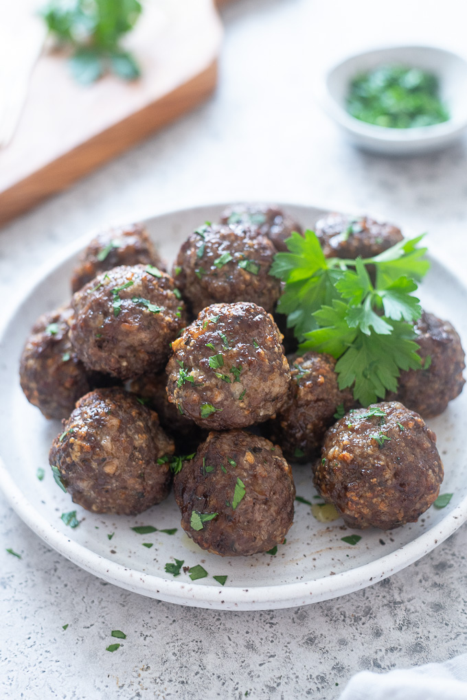 Air fryer meatballs piled up on a white plate