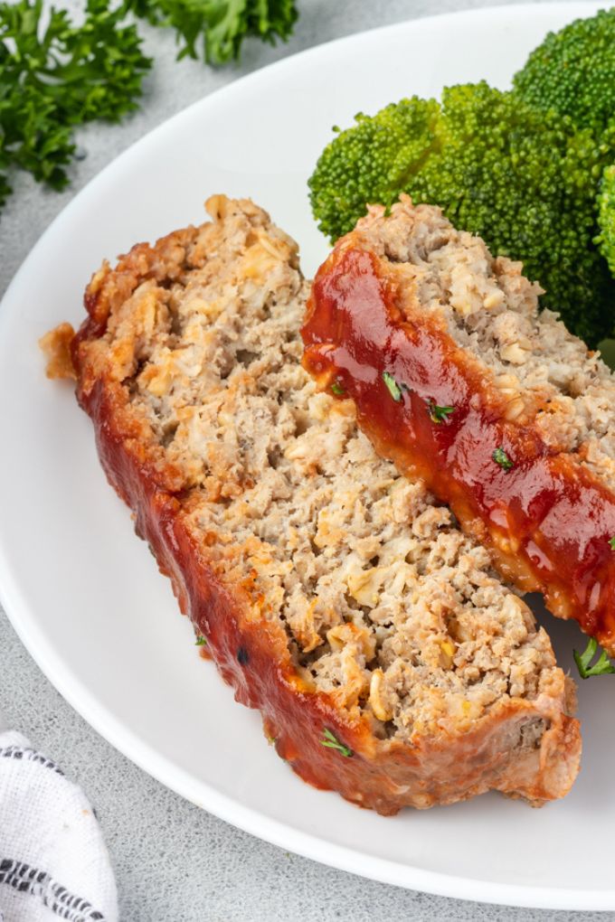 Slices of turkey meatloaf with oatmeal on a plate with broccoli