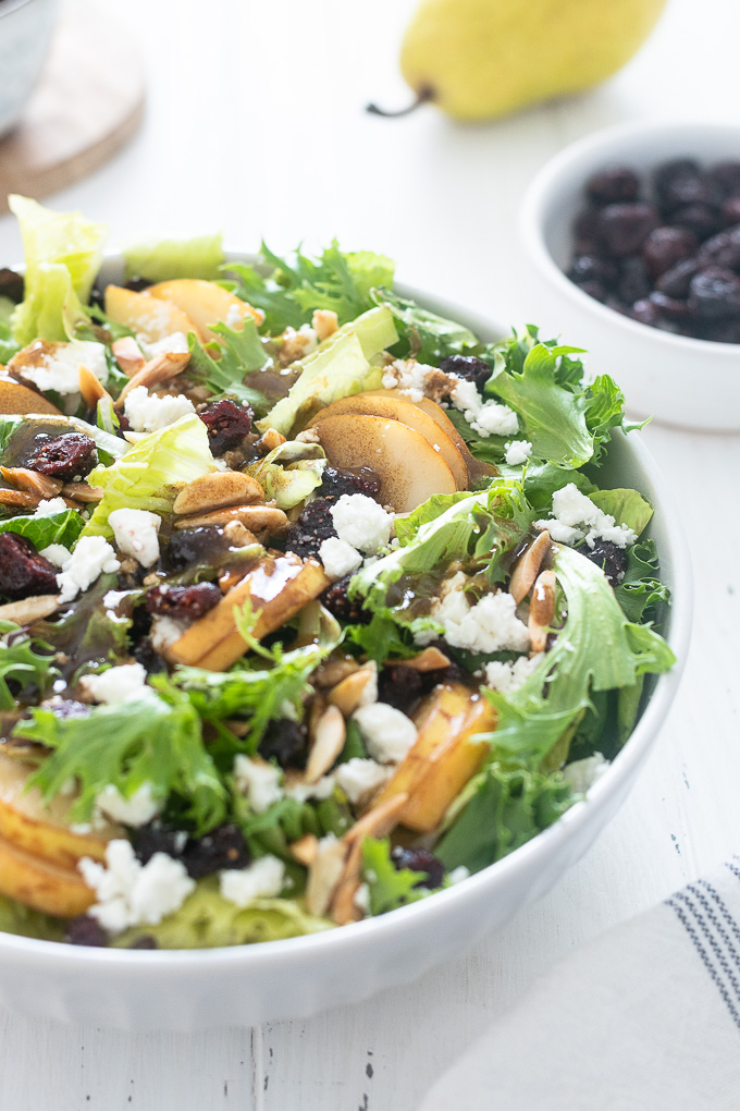 Pear salad in a white bowl with balsamic dressing