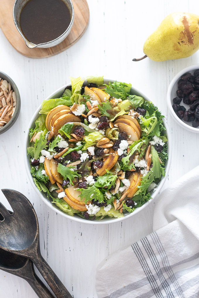 Pear salad in a bowl with feta, cranberries and balsamic