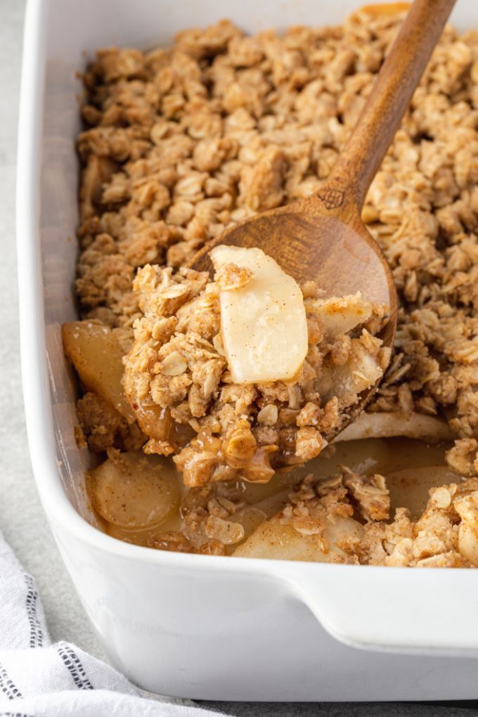Spoonful of pear crumble over baking dish