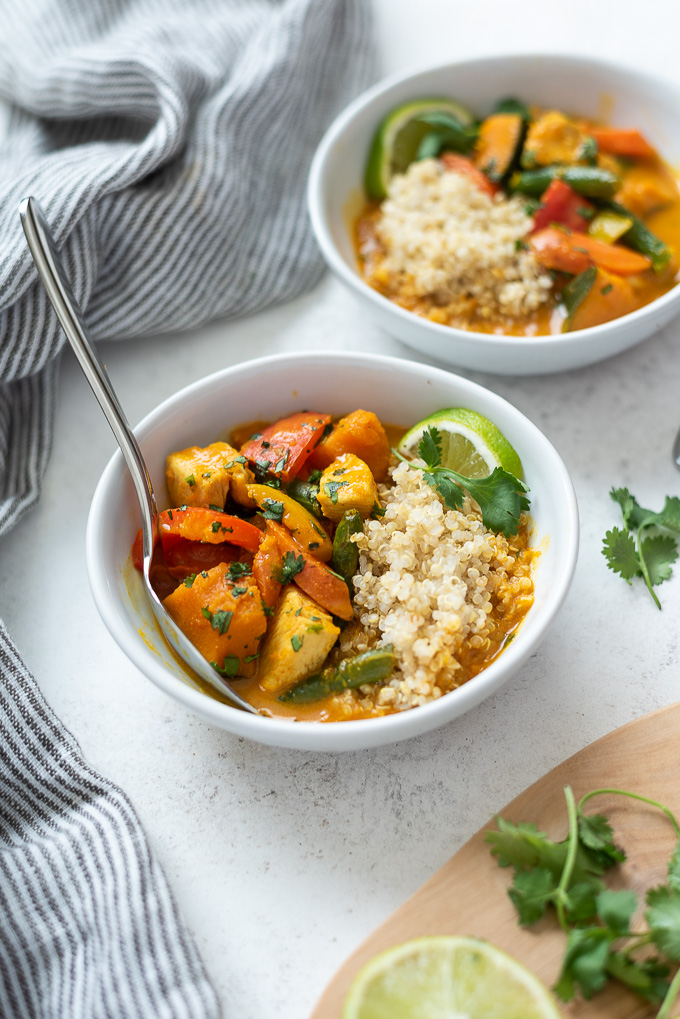 Pumpkin curry over quinoa in a bowl with lime