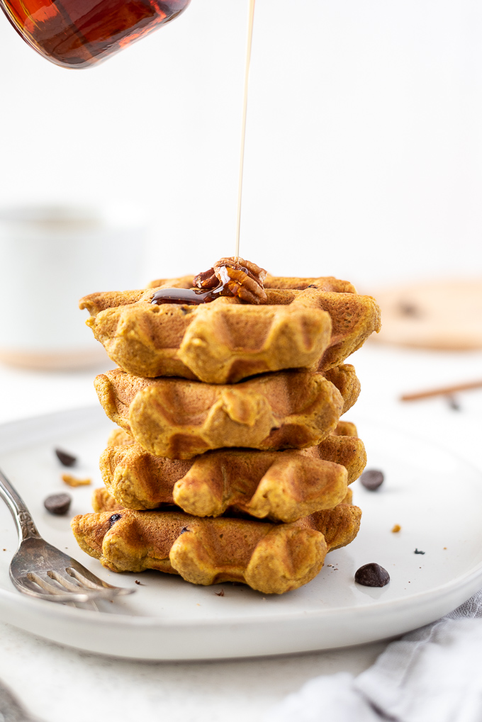 Maple syrup drizzling over healthy pumpkin waffles