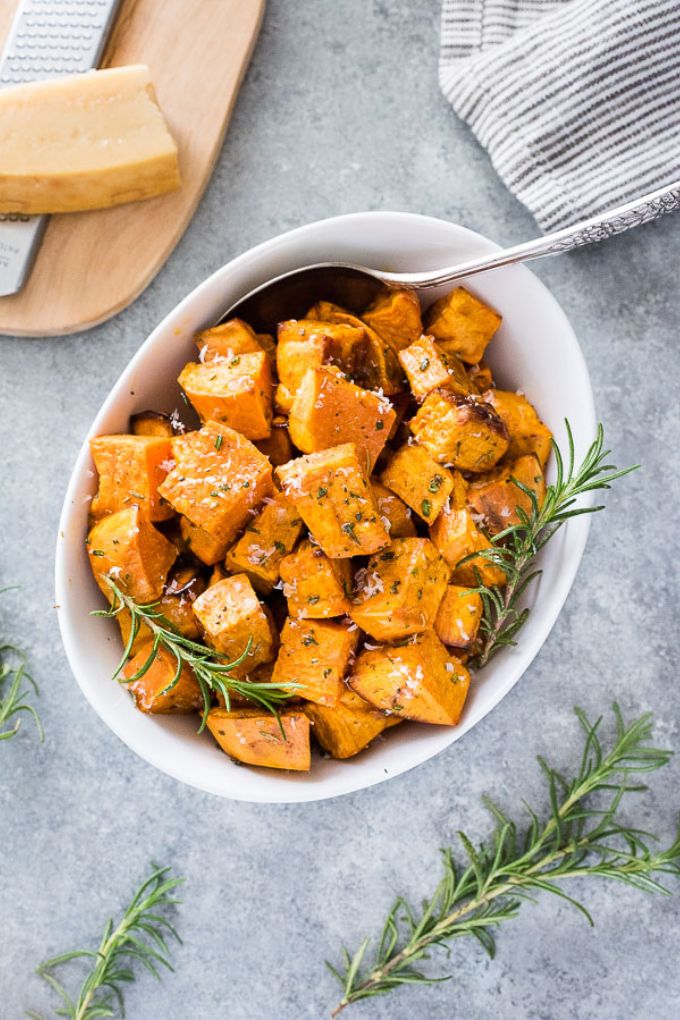Oven roasted sweet potatoes in a white serving bowl