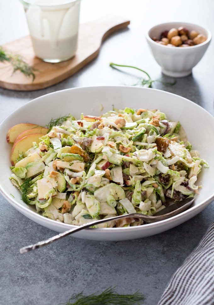 Shaved brussels sprout salad in a bowl with serving spoon