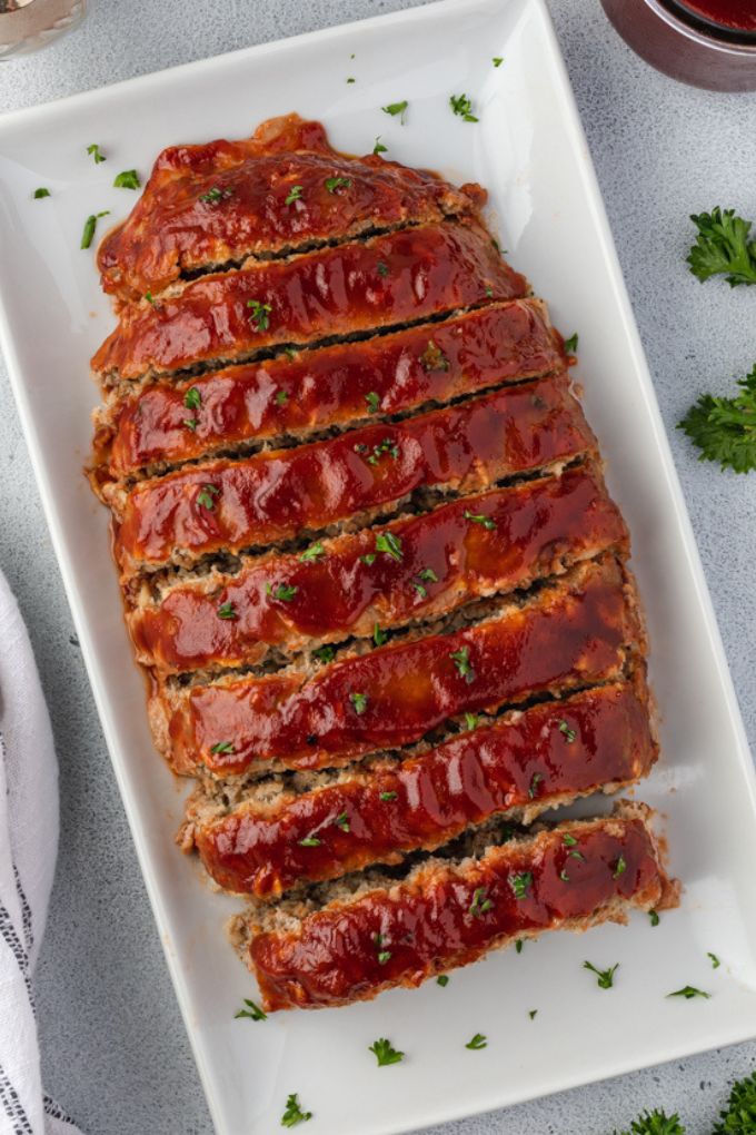 Sliced bbq turkey meatloaf on a platter with parsley