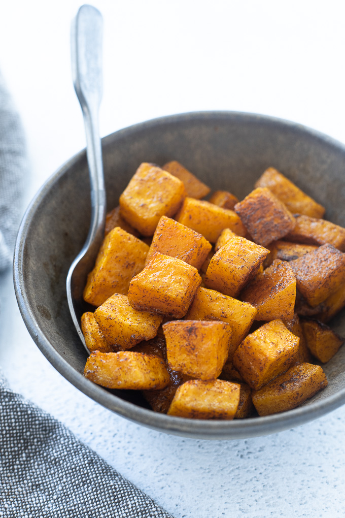 Cinnamon roasted butternut squash in a bowl with a spoon
