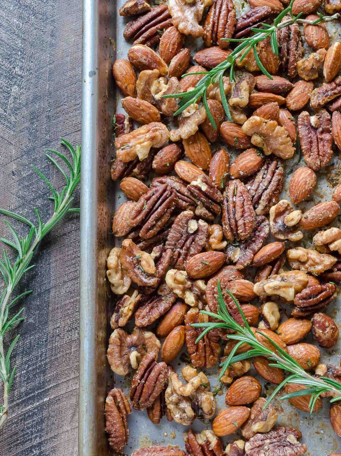 Roasted nuts on a sheet pan with rosemary
