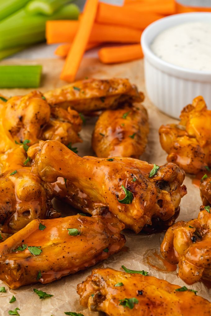 Honey buffalo chicken wings piled on parchment paper