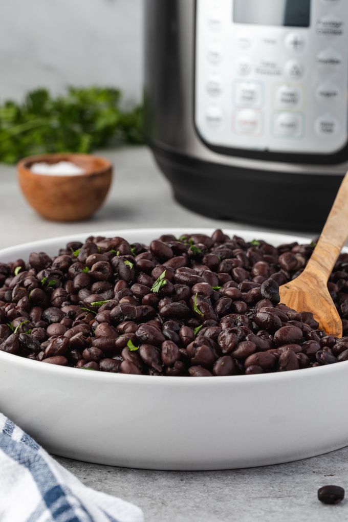 Instant pot black beans in a bowl with instant pot in the background