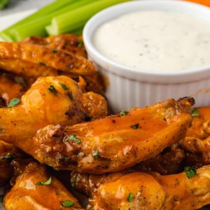Instant pot chicken wings piled on a plate with ranch dip