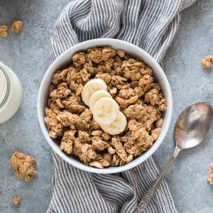 Peanut butter granola in a bowl with sliced banana on top