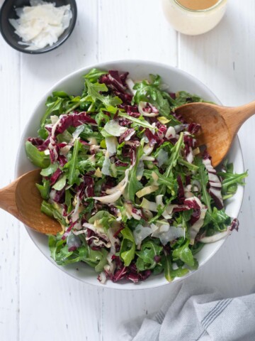 Tricolore salad in a bowl with wooden servers