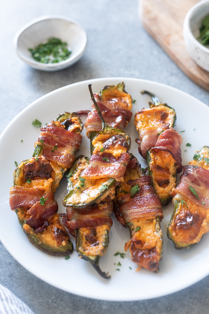 Plate of air fryer jalapeno poppers wrapped in bacon