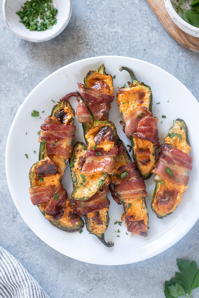 Bacon wrapped jalapeno poppers on a white plate