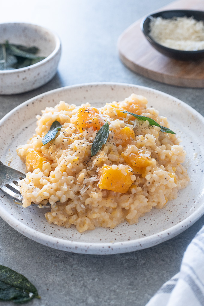 Plate of butternut squash risotto with crispy sage leaves on top