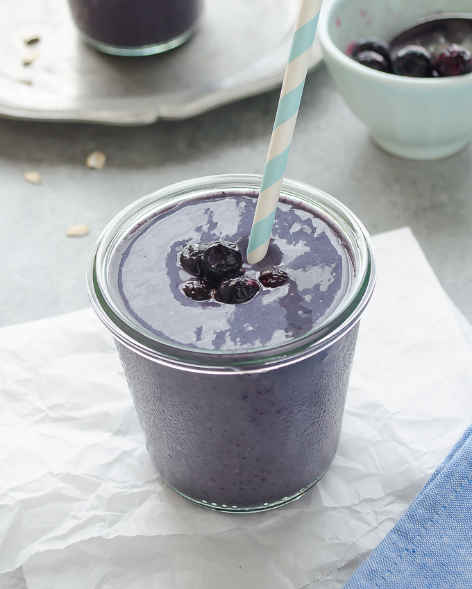 Blueberry and banana smoothie in a jar with a straw