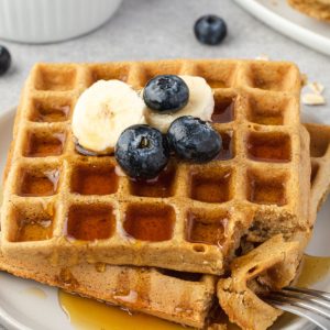 Oat waffles on a plate with banana and blueberries