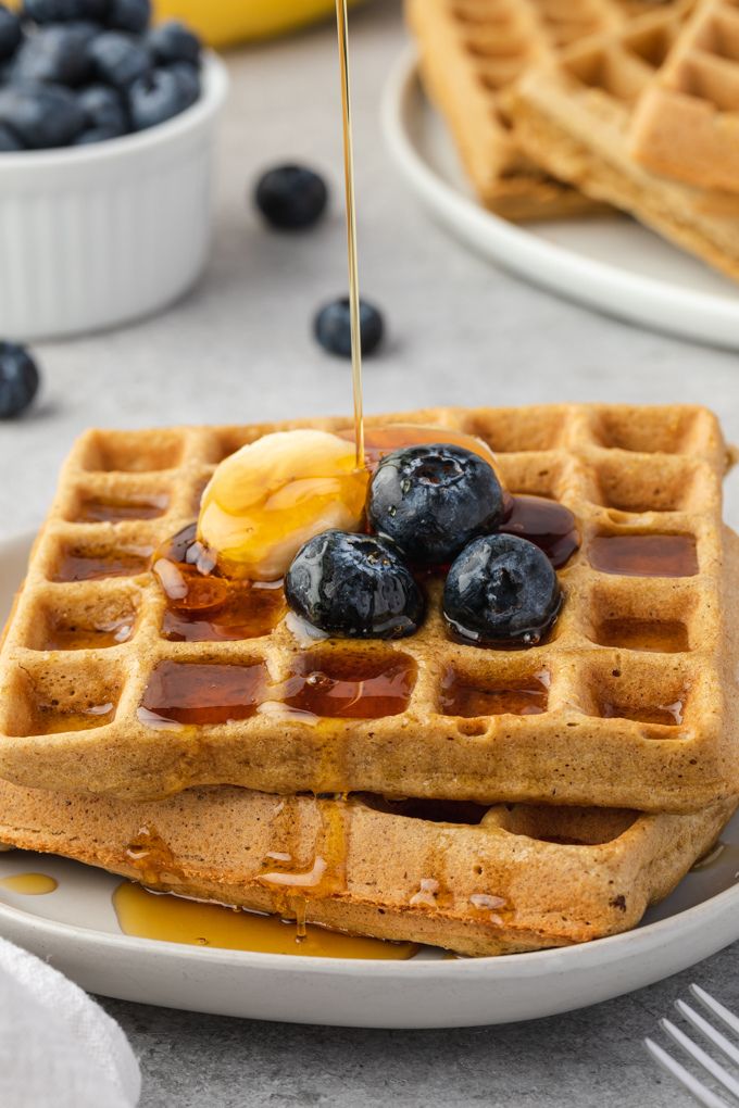 Gluten-free waffles with maple syrup pouring over the top