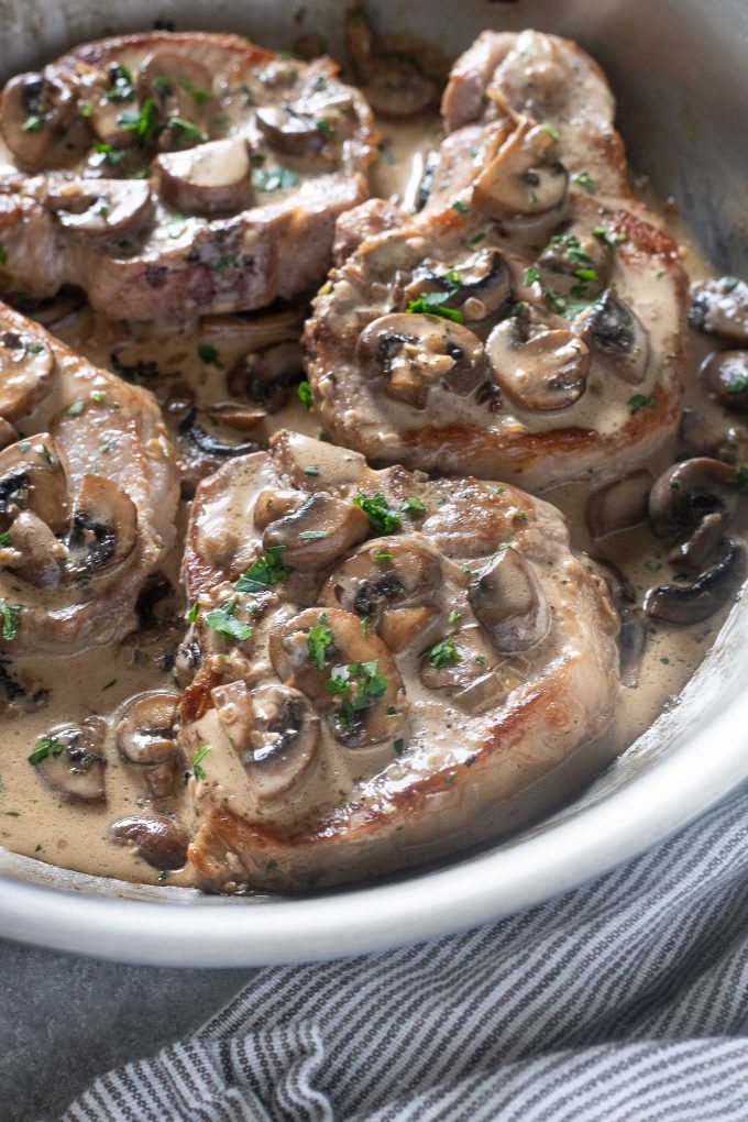 Pork chops with creamy mushroom sauce in pan