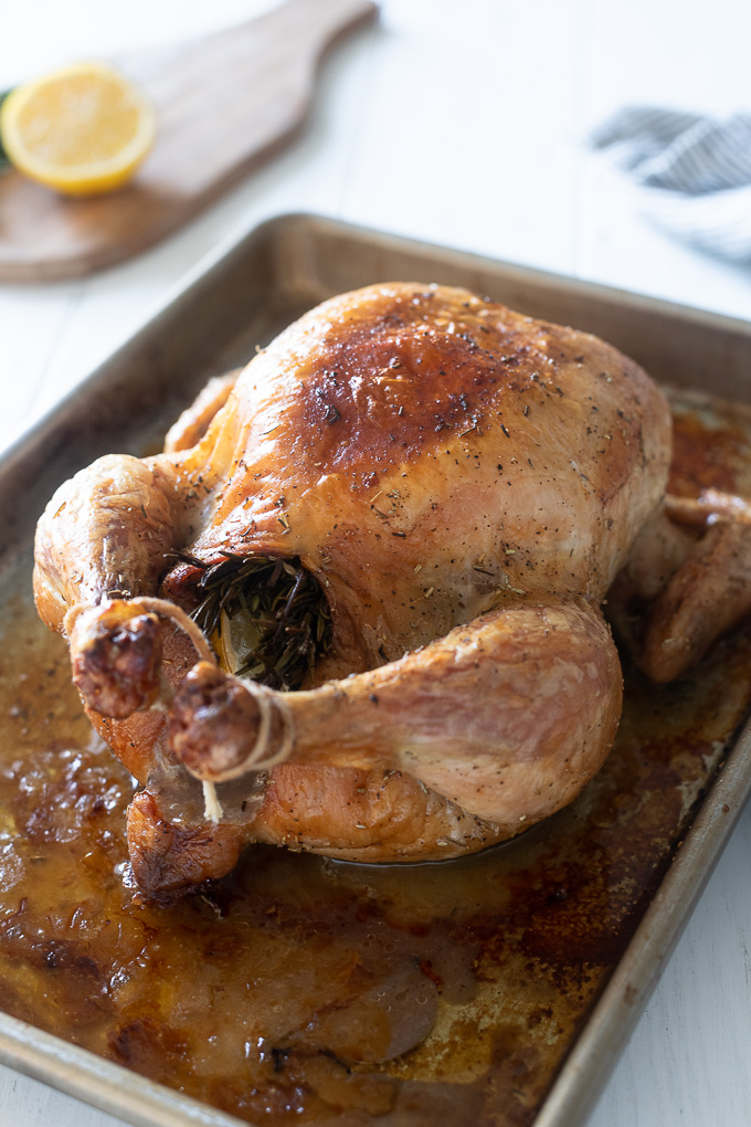 Whole roasted chicken trussed on a baking sheet