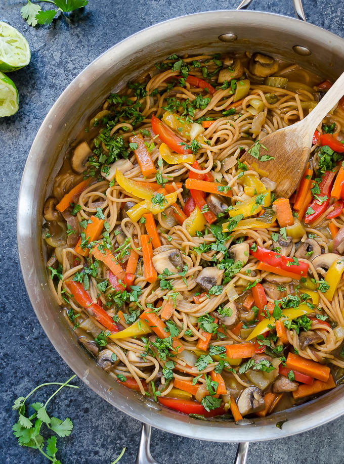 Thai pasta in a skillet with a wooden spoon