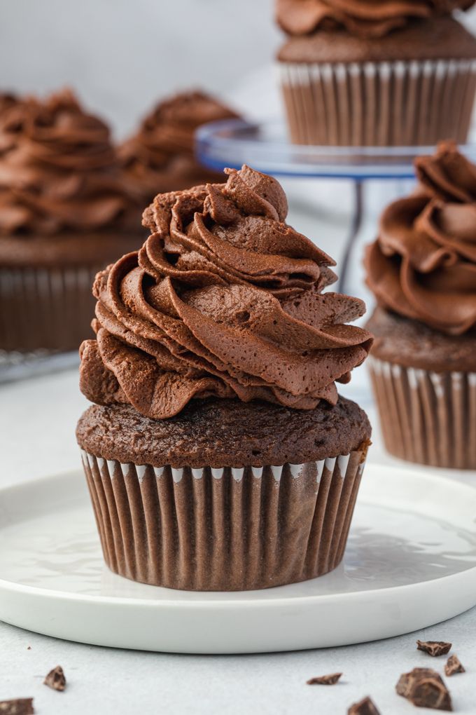 Whipped chocolate ganache frosting piped on a cupcake