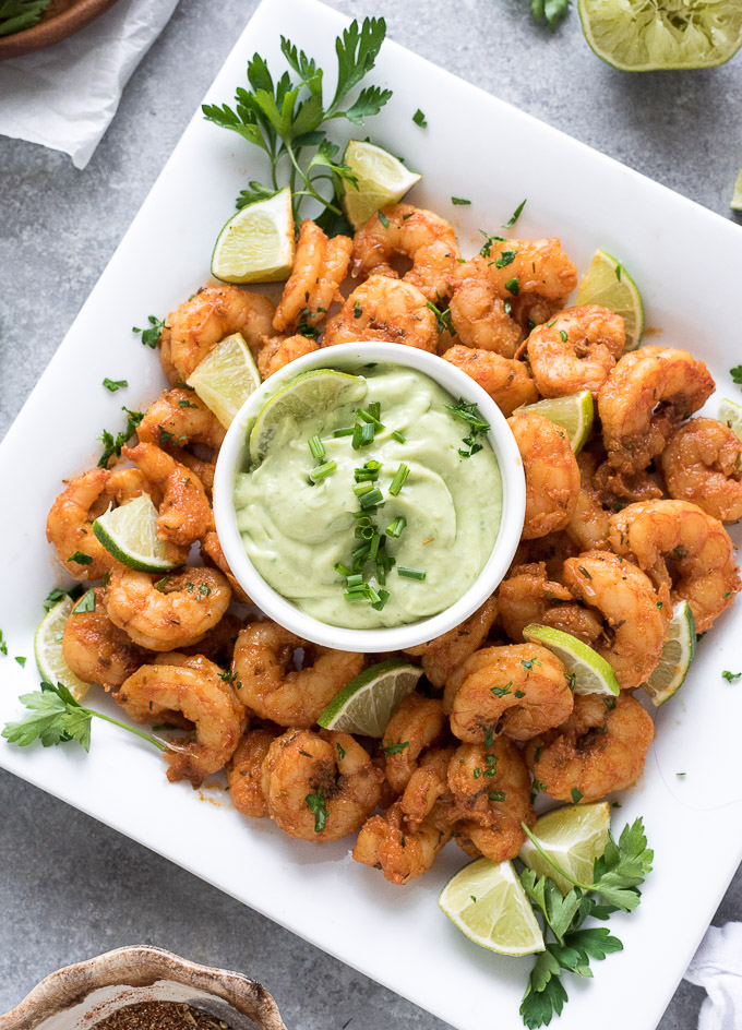 Blackened shrimp on a platter with avocado ranch dressing