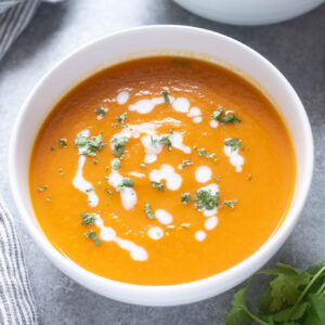 Carrot ginger soup topped with coconut milk and cilantro