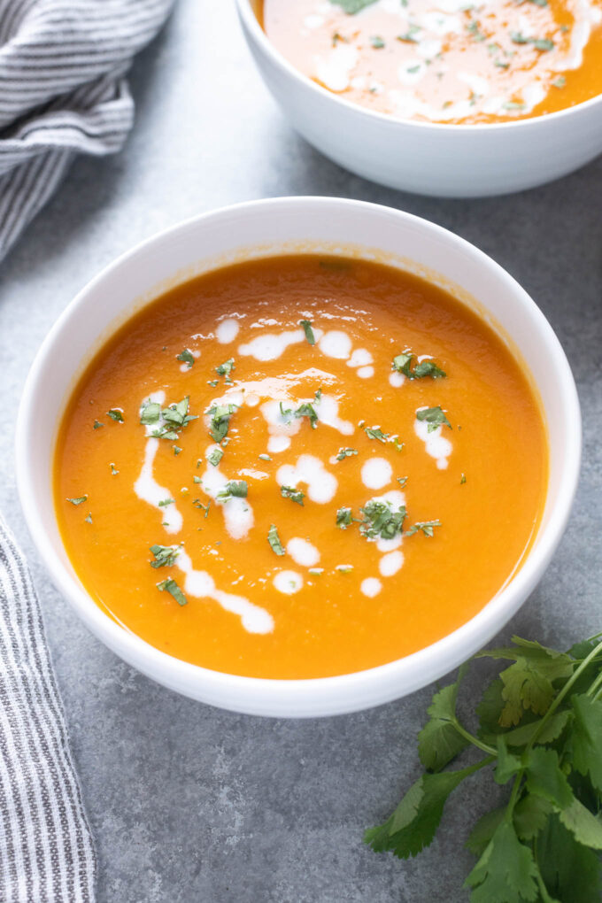 Carrot ginger soup topped with coconut milk and cilantro