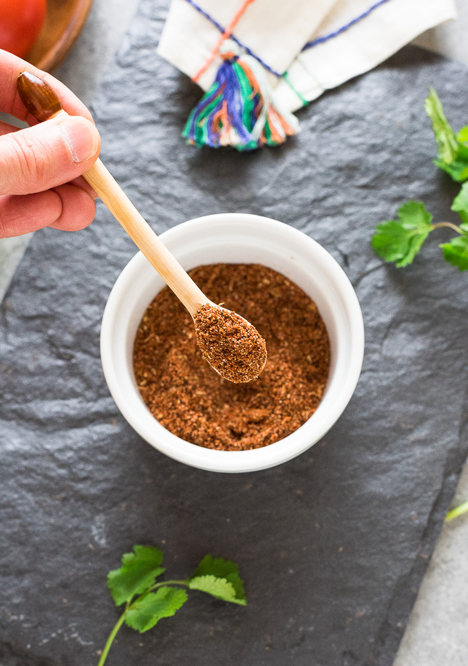 Spoonful of Mexican spice mix over a bowl
