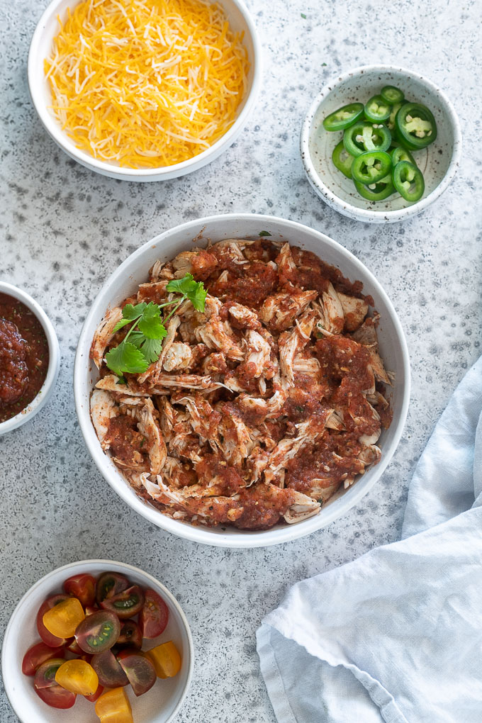 shredded salsa chicken in a bowl with topping