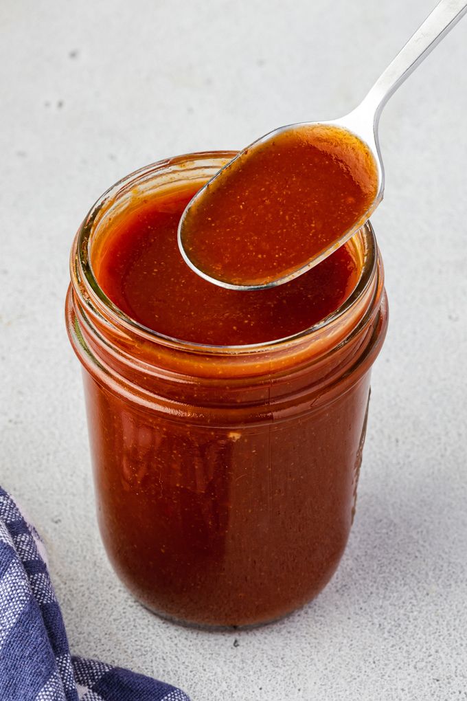 Bourbon barbecue sauce in a jar with a spoon